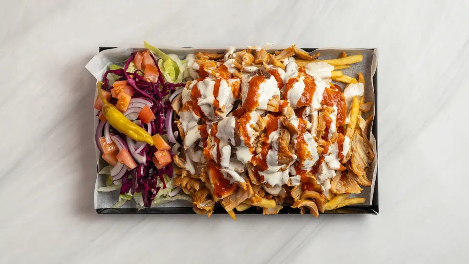 Tallrik med kebab, pommes och sås
